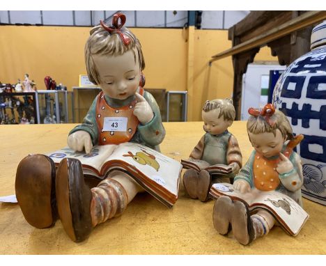 THREE GOEBEL HUMMEL FIGURES TO INCLUDE A LARGE MODEL OF A GIRL READING A BOOK, NO.620, HEIGHT 25CM AND A PAIR OF BOY &amp; GI