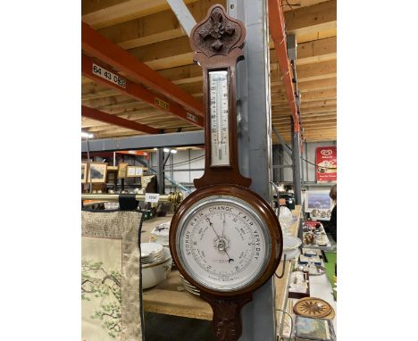 A MAHOGANY CASED ANEROID BAROMETER WITH CARVING TO THE TOP AND BOTTOM 