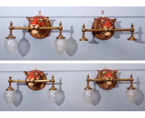 Group of four interesting 20th century tiger mask wall lights ceramic head with brass poles to mouth with twin fittings (4)