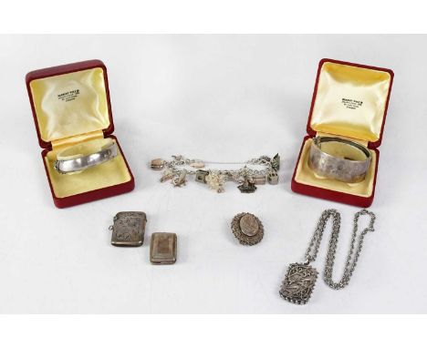 A collection of silver jewellery comprising two bangles, one with engine turned decoration, a vesta, a vinaigrette, a lozenge