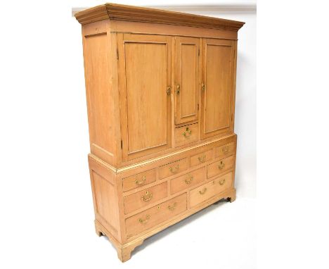 A 19th century rustic pine linen cabinet, the top with small cupboard over a single drawer, flanked by two cabinets, resting 