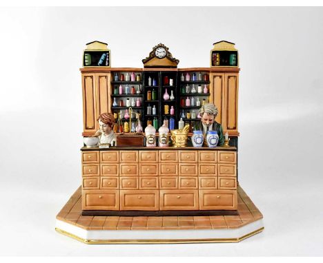 CAPODIMONTE; a model of a pharmacy or apothecary with chemist and his apprentice making pills at a counter, with a background