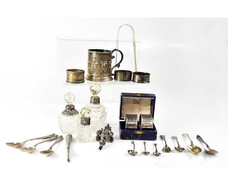 A collection of hallmarked silver items to include a Victorian rattle (af), teaspoons, napkin rings, a mug, and sugar tongs, 