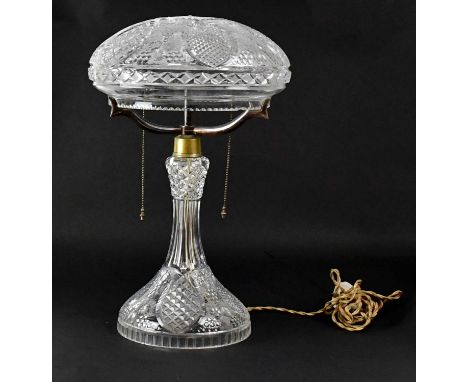 A cut glass mushroom-shaped table lamp with silver plated mounts holding double-bulb mechanism, on a flared base decorated wi