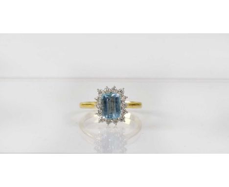 An 18ct gold cluster ring set with emerald cut topaz in a surround of fourteen diamonds, stamped '750', size P, approx. 3.4g.