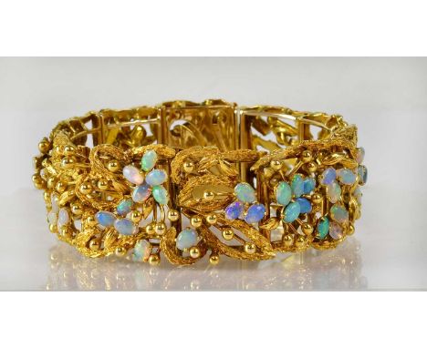 A c.1960s 18ct yellow gold floral bracelet set with oval opal cabochons, gold stamens and leaves, length approx. 18cm, width 
