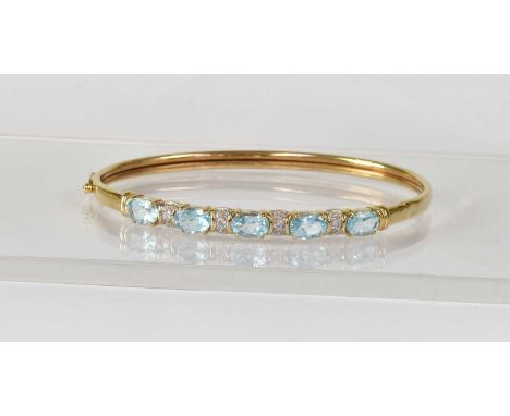 A 9ct yellow gold bangle set with blue and white stones, approx. 7.4g.Condition Report: - Stamped '375' to the interior.
