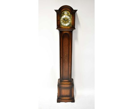 An early 20th century oak cased Westminster chiming grandmother clock with triple drum movement striking on a gong, the arche