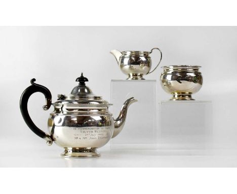 A George V hallmarked silver three-piece tea service of globular form, comprising a teapot with wooden handle and knop, engra