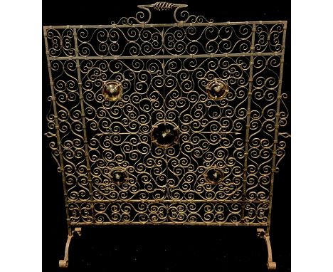 An early 20th century hand made wrought iron fire screen, set with five yellow glass roundels, 73cm high 