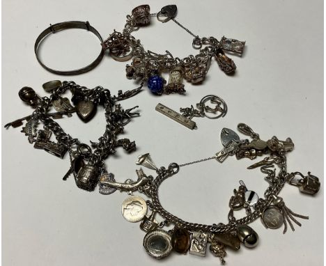 A silver curb link charm bracelet, including treasure chest, Robin Hood, police helmet, flying carpet, gondola, Daschund, etc