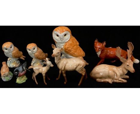 A Beswick stag, doe and fawn group; a Beswick model of an owl, number 046, 18cm; two smaller, number 2026, 12cm; a Beswick mo