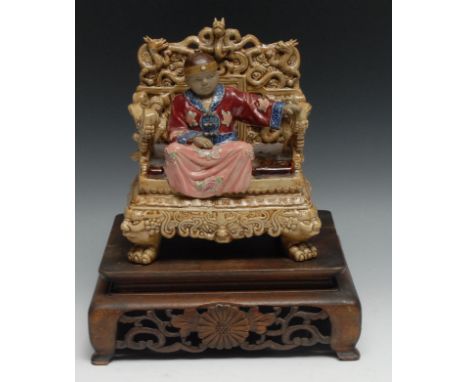 A Chinese high fired stoneware figure, of a boy emporer, seated, glazed in polychrome, 19cm high, seal marks, hardwood stand 