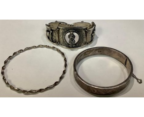 A silver bangle, Chester 1962; a silver coloured metal bracelet; another (3) 