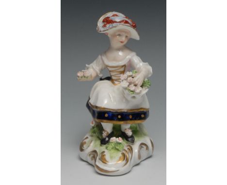 A Derby Patch Mark figure, of a girl seated holding a basket of flowers, scroll base, 12.5cm high, c.1770 