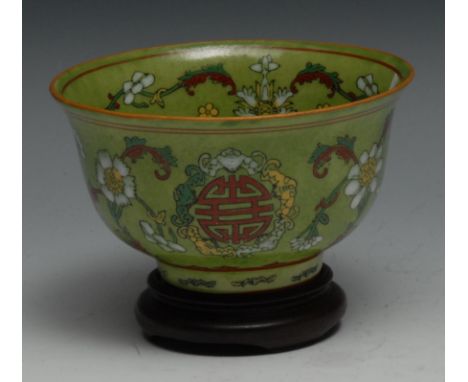 A Chinese circular bowl, decorated in polychrome enamels with flowers and symbol on an apple green ground, 12.5cm diam, red f