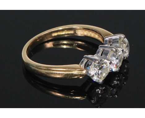 An 18ct gold diamond ring, the three brilliant cut claw set stones approx. 1.5ct total diamond weight, platinum bezel, size R