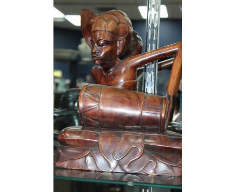 20TH CENTURY SOUTH EAST ASIAN CARVED MAHOGANY FIGURE OF A DRUMMER
in the Thai or Burmese style, modelled as seated with angul
