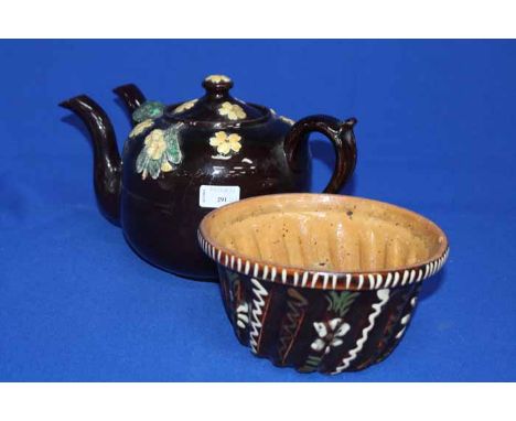 TREACLE GLAZED EARTHENWARE DOUBLE SPOUTED TEAPOT
with relief Primrose decoration, 35cm long; together with a similar earthenw