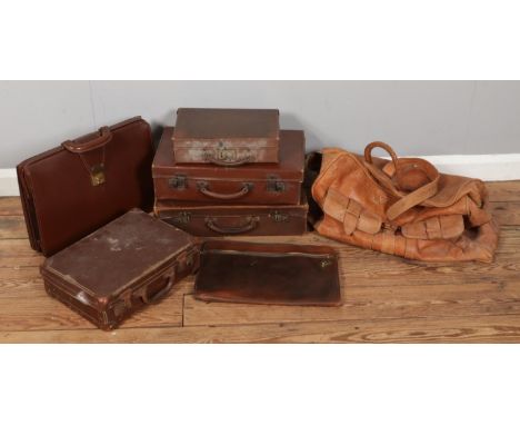 A collection of vintage leather hard suitcases, briefcase and bag.