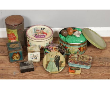 A collection of vintage tins in various sizes, two of which contain knitting materials and wooden tools.