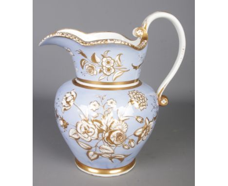 A Victorian ceramic wash jug, gilt decorated with floral motifs.