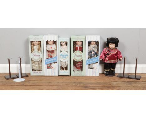 A box of porcelain dolls and doll stands, including examples from 'The Promenade Collection'.