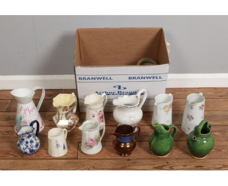 A large box containing an assortment of water jugs, primarily ceramic in various sizes.