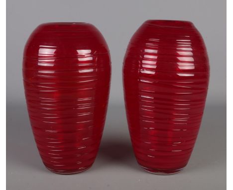 In the style of Fulvio Bianconi, a near pair of ruby red hand blown glass vases. Height approximately 28cm.