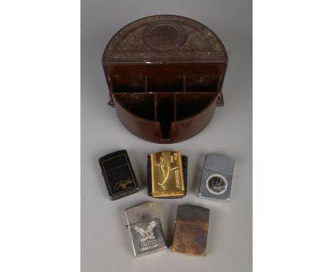 A vintage Bakelite cigarette dispenser with contents of assorted lighters to include Malboro, Zippo and Raffles.