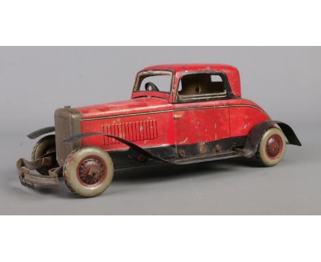 A 1947 Chad Valley clockwork 'Ubilda' tin plate coupe car.  Play-worn, missing key, but has been tested and mechanism works.
