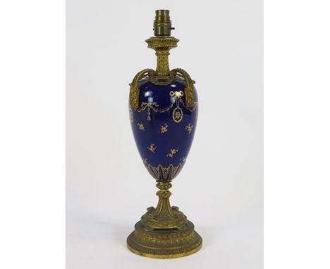 A Royal Worcester porcelain and ormolu mounted table lamp of ovoid tapering form, with gilt garland decoration to a cobalt bl