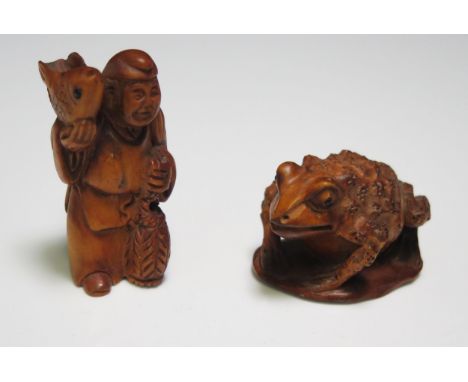 A Japanese carved boxwood netsuke in the form of a toad, with inset glass eyes, signed, 5cm long, and another of a man with a