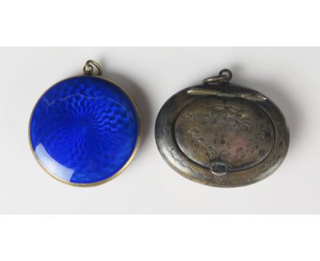 A silver gilt and enamel powder compact pendant, of circular outline, 4cm diameter, together with an oval silver example, 5cm