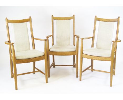Three Ercol Windsor Penn elbow chairs, with cushion backs and  cushion seats, on turned legs linked by stretchers, (3).