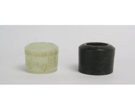 A carved pale jade archers ring, 2.5cm wide, together with a mottled jade archers ring. 3cm wide.