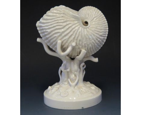 A Belleek porcelain conch shell raised on a naturalistic coral circular base, 21cm high.