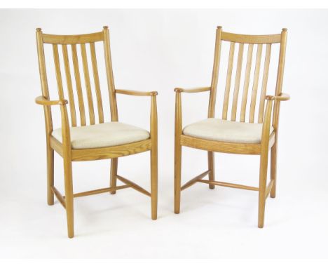 A pair of Ercol Windsor Penn elbow chairs, with slatted backs cushion seats, on turned legs linked by stretchers, (2).