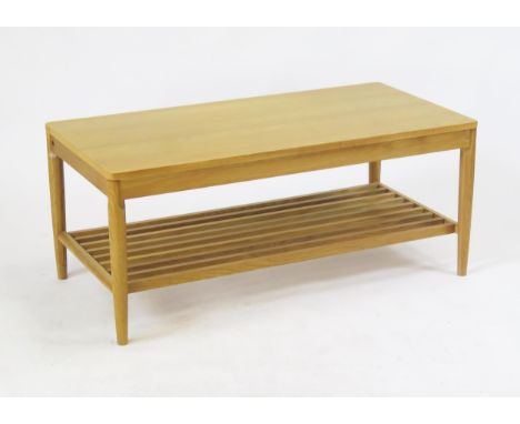 An Ercol rectangular coffee table, raised on turned and tapering legs linked by a slatted under tier, 100cm long, 50cm wide, 