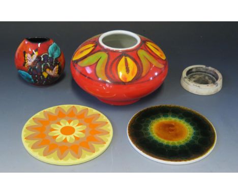 A Poole pottery Delphis pattern vase19cm diameter, a Poole pottery butterfly vase, 10cm high, and two retro pottery coasters.