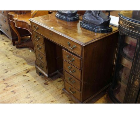 Georgian mahogany kneehole desk having a long drawer above two banks of four drawers and central inset cupboard door on brack