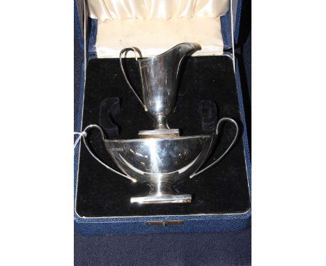 Cased silver helmet cream jug and two handled sugar basin, London 1934