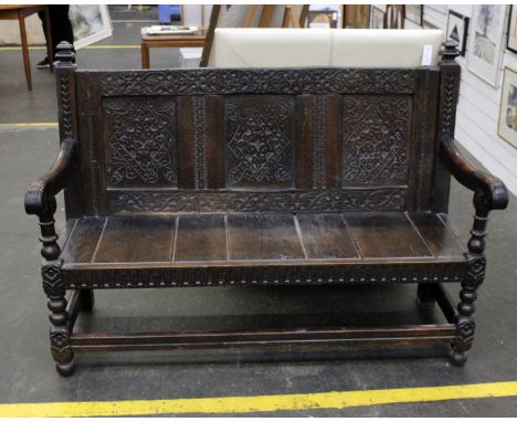A part 17th century oak bench, the chip carved panel back married with a later 19th century construction.137cm(W) x 56cm(D) x