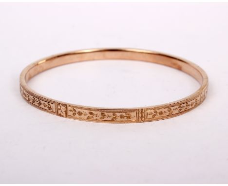 A 9ct gold bangle bracelet with bright cut decoration. 7.5g