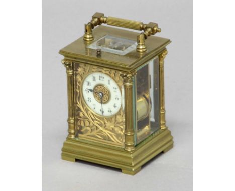GILT BRASS FOUR PANE CARRIAGE CLOCK, the ivorine dial in a scrolling floral frame on an eight day half hourly striking and re