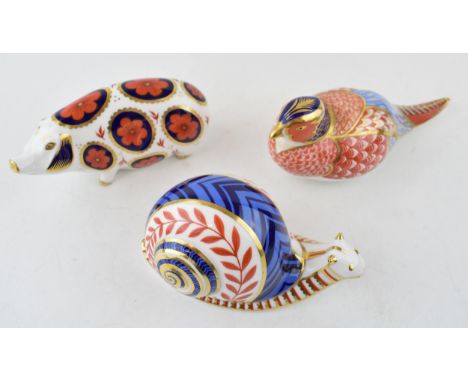 Royal Crown Derby paperweights in the form of an imari pig, a garden snail, both ceramic stoppers and a pheasant (no stopper)