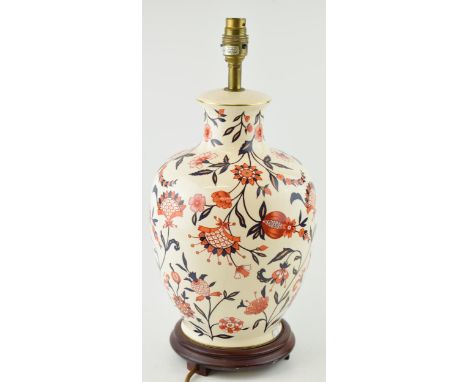 A Wade lamp base in a country house style with floral decoration in red / orange and blue with gilt lining. Height 45cm.  In 