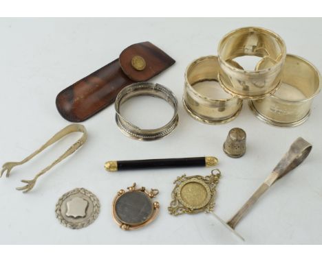 A collection of silver items to include napkin rings, thimble, fob and sugar nips (approx 90 grams) together with a propellin