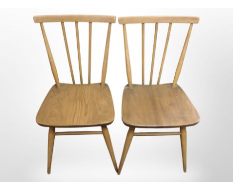 A pair of Ercol elm and beech spindle-back dining chairs.