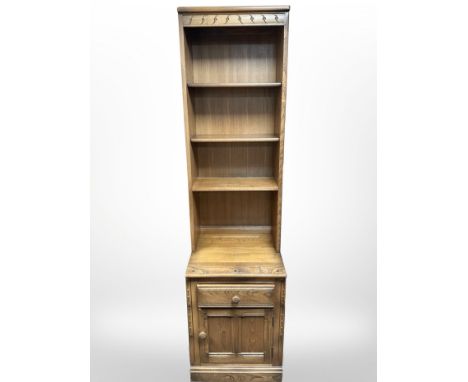 An Ercol elm open bookcase, 52cm wide x 49cm deep x 196cm high.